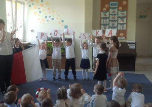Dzieci próbują ułożyć z podanych liter napis Polska.