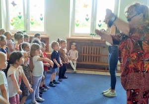 Dzieci patrzą na Panie i razem z nimi ilustrują ruchem treść śpiewanej piosenki.