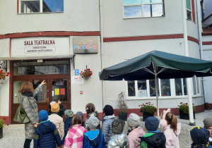 Dzieci wraz z nauczycielką stoją przed teatrem Piccolo
