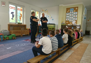 Dzieci z grupy Motyli słuchają Funkcjonariuszy Straży Miejskiej.