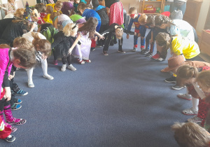 Dzieci tańczą trzymając się za kolana