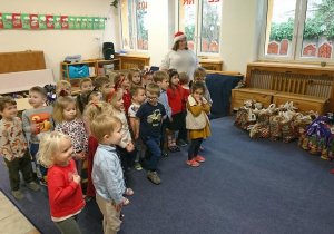 Zdjęcie przedstawiające, jak dzieci słuchają Mikołaja.