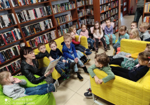 Dzieci słuchają wiersza czytanego przez Bibliotekarkę