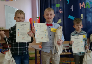 Chłopcy stoją i pokazują dyplomy za udział w konkursie