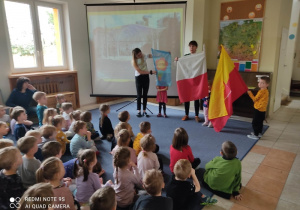 Nauczycielki pokazują dzieciom flagi
