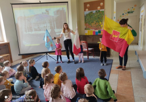 Nauczycielki pokazują dzieciom flagi