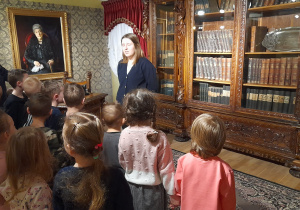 Dzieci słuchają przewodnika w muzeum