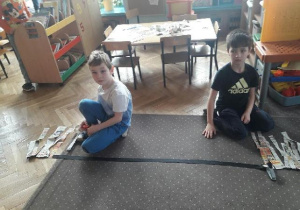 Dwóch chłopców siedzi na dywanie