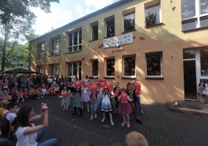 Przedszkolaki tańczą z balonikami w kształcie serc