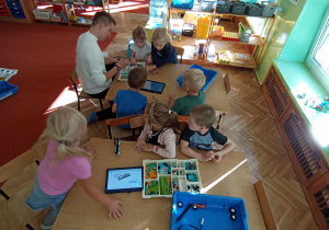 Dzieci przy stolikach budują z klocków