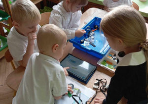 Dzieci układają klocki lego według instrukcji.