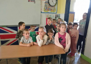 Dzieci stoją przy ławce w sali leksyjnej