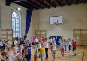 Dzieci ćwiczą na sali gimnastycznej
